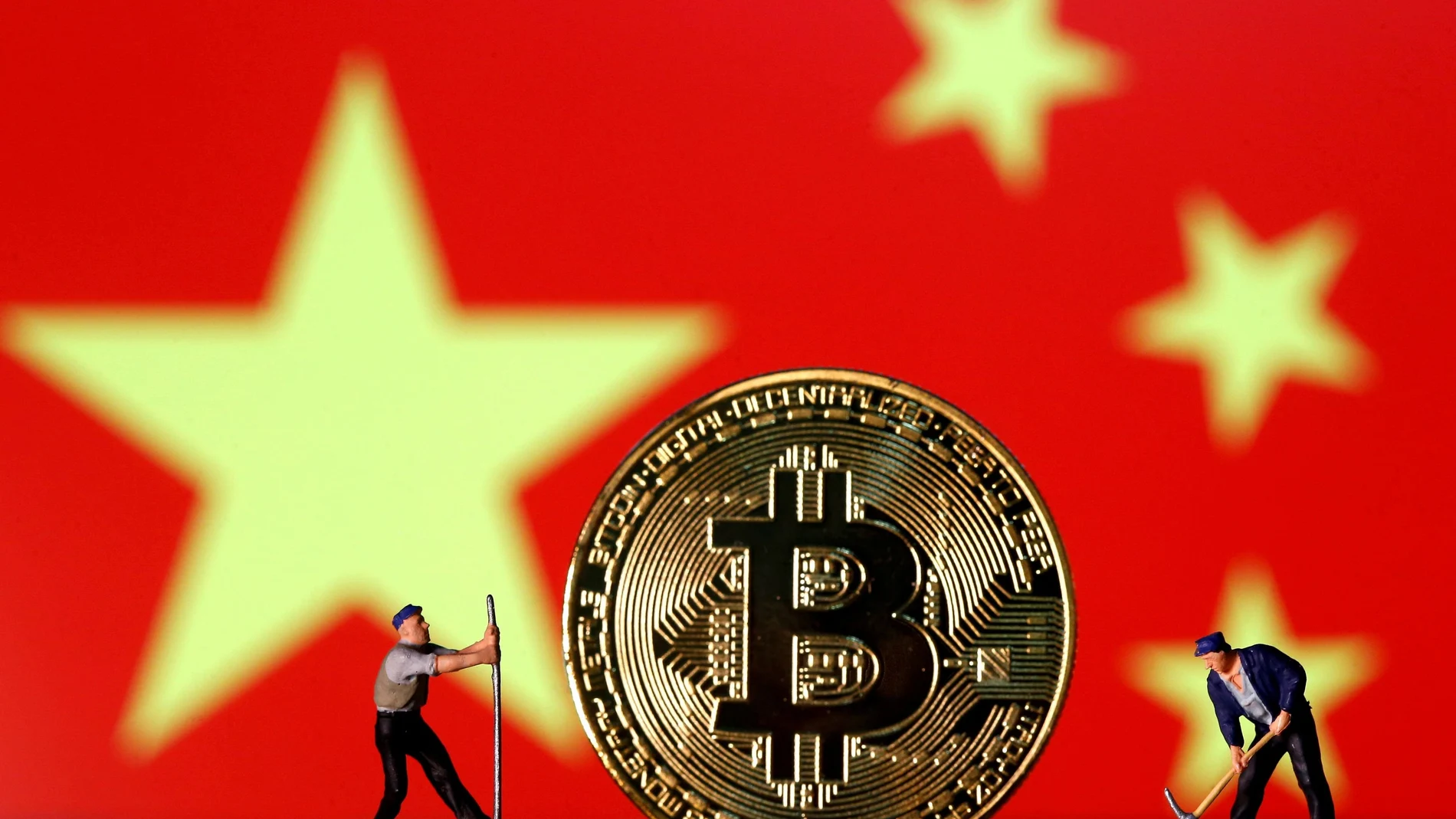 FILE PHOTO: Small toy figurines are seen on representations of the Bitcoin virtual currency displayed in front of an image of China's flag in this illustration picture, April 9, 2019. REUTERS/Dado Ruvic/Illustration/File Photo