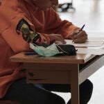 Un alumno con una mascarilla en el pupitre de un centro educativo