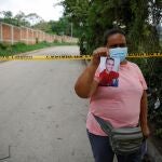 Marleny Barrientos shows a picture of her son who went missing six years ago and is believed to be at the site authorities are excavating a clandestine cemetery discovered at the house of a former police officer and containing as many as 40 bodies, most of them believed to be women in Chalchuapa, El Salvador May 20, 2021. REUTERS/Jose Cabezas