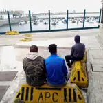 En la imagen, tres menores de edad marroquíes cfontemplan el puerto de Ceuta, desde el que quieren cruzar a la Península EFE/Manuel Rus