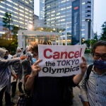 Tokyo (Japan), 21/05/2021.- Protesters against Tokyo 2020 Olympic Games are forced to remove by security guards of a building as they appeal to commuters leaving offices at a building housing office of Tokyo 2020 organizing committee, in Tokyo, Japan, 21 May 2021, as a three-day meeting of the IOC Coordination Commission for the Games of the XXXII Olympiad will be concluded. The International Olympic Committee, the Tokyo 2020 Organising Committee, the Tokyo Metropolitan Government, the Japanese Olympic Committee, the Government of Japan and other relevant parties participate in the meeting. More than 80 per cent of Japanese people think to cancel or postpone the Tokyo Olympic Games in an opinion poll by a Japanese TV on mid-May. (Protestas, Japón, Tokio) EFE/EPA/KIMIMASA MAYAMA