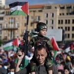 Un seguidor de Hamas porta a su hijo sobre los hombros en una manifestación pro palestina en Líbano