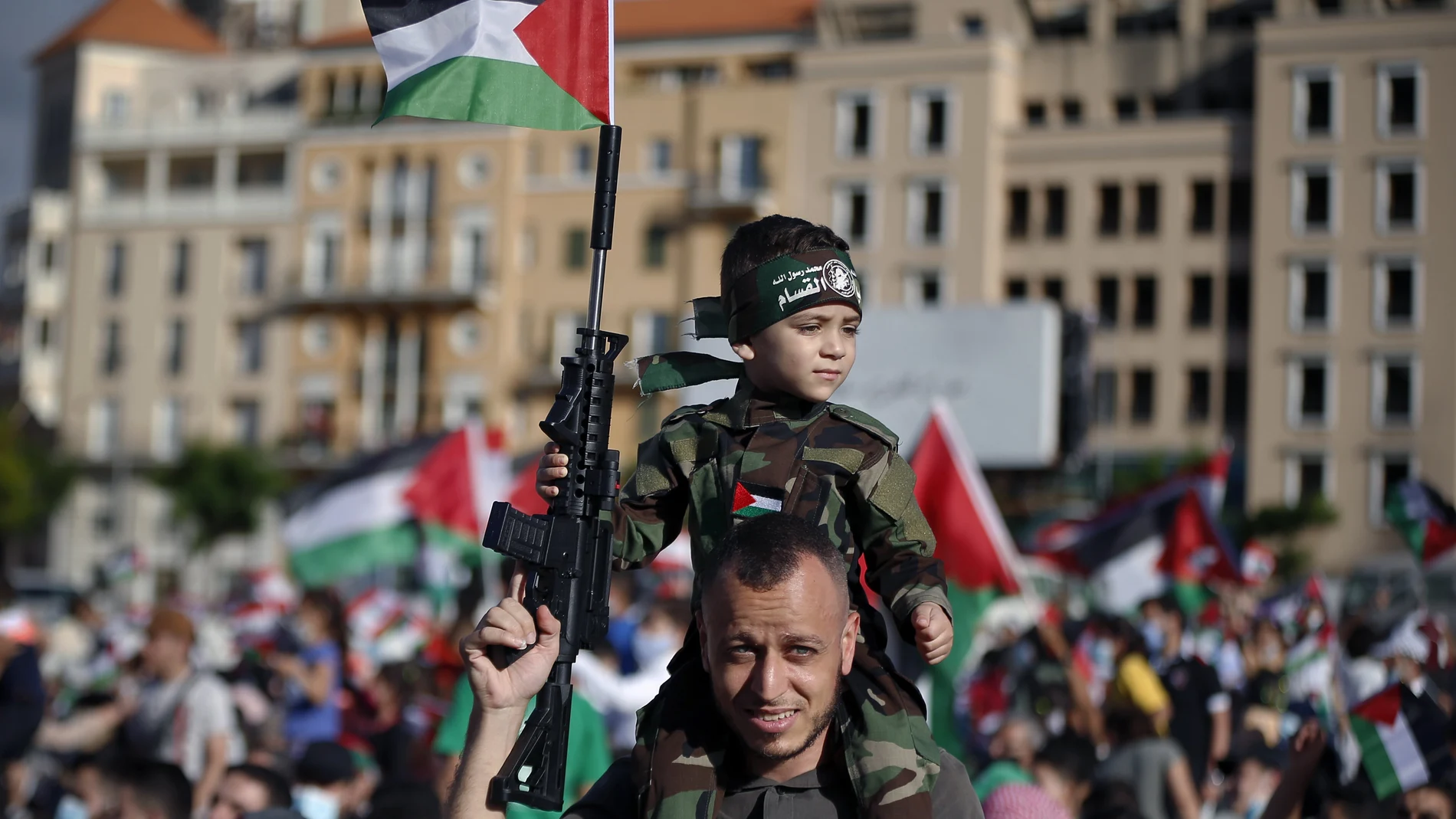 Un seguidor de Hamas porta a su hijo sobre los hombros en una manifestación pro palestina en Líbano