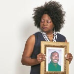 Beverly Smith junto a un retrato de su hijo asesinado por un agente de seguridad en 2015