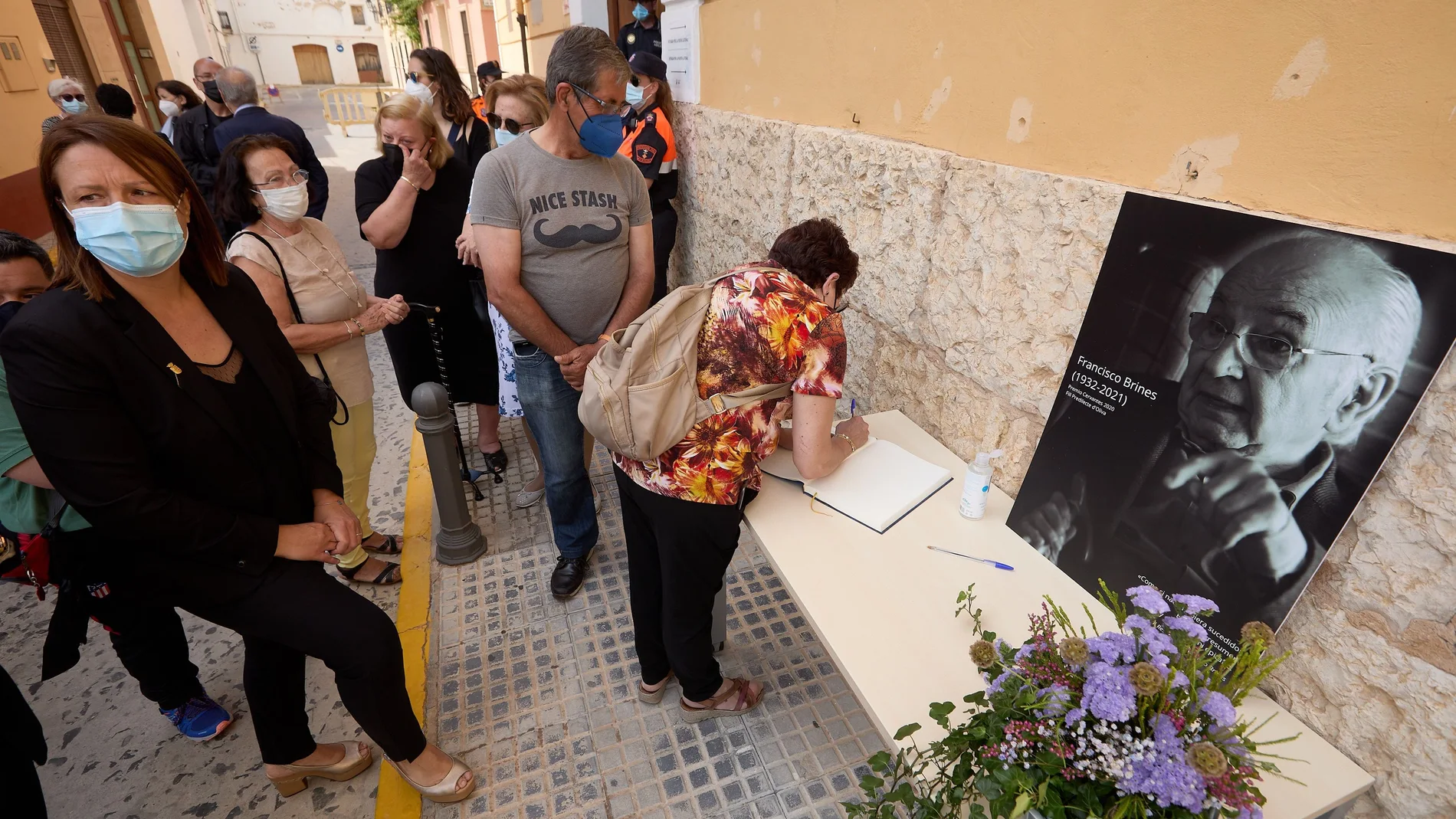 Una vecina de Oliva escribe en el libro de condolencias de la capilla ardiente con los restos mortales del poeta Francisco Brines, que el Ayuntamiento de Oliva ha abierto este sábado, poco después de las 10 horas