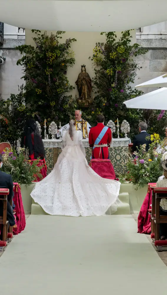 Detalle de la espalda del vestido de la novia con una gran cola bordada con flores
