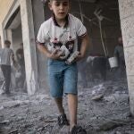Niños recogen los escombros en la Franja de Gaza este fin de semana tras la firma del alto el fuego