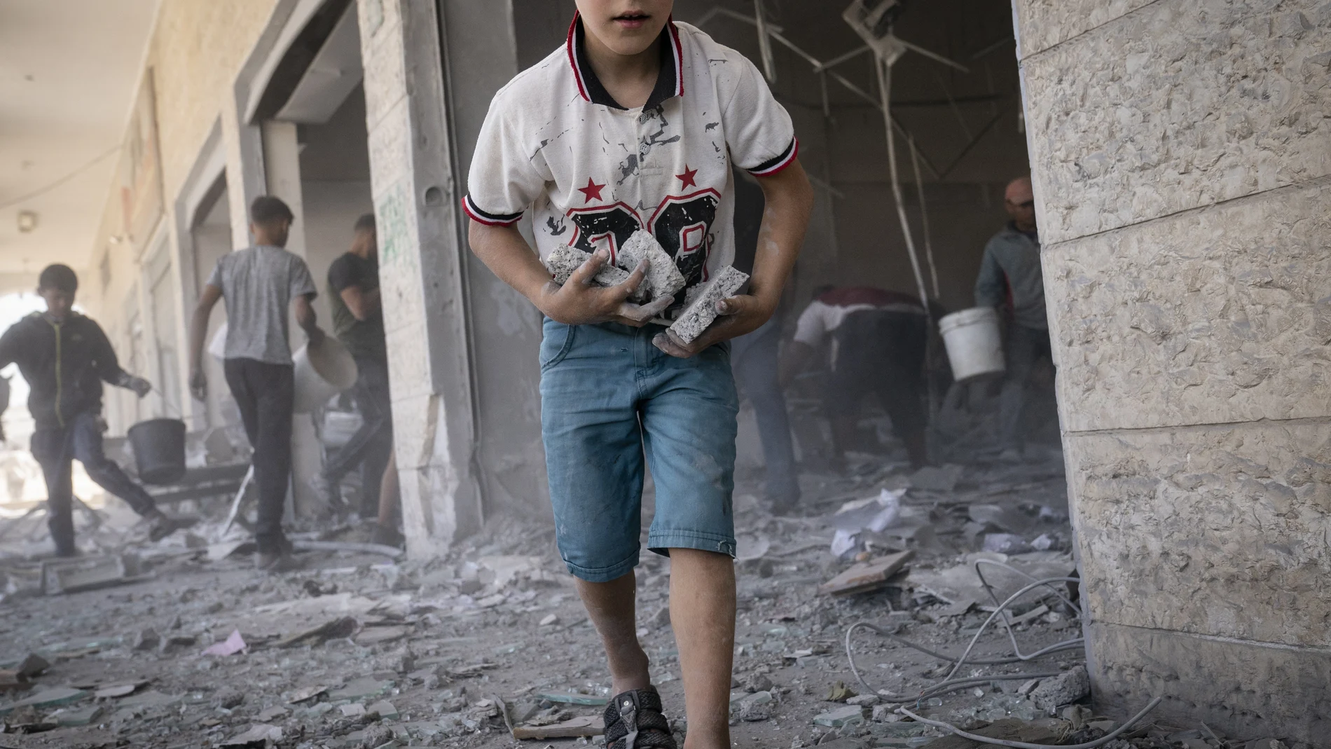 Niños recogen los escombros en la Franja de Gaza este fin de semana tras la firma del alto el fuego