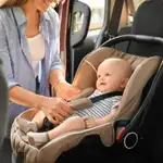 Una madre ajusta la silla de su bebé en el coche