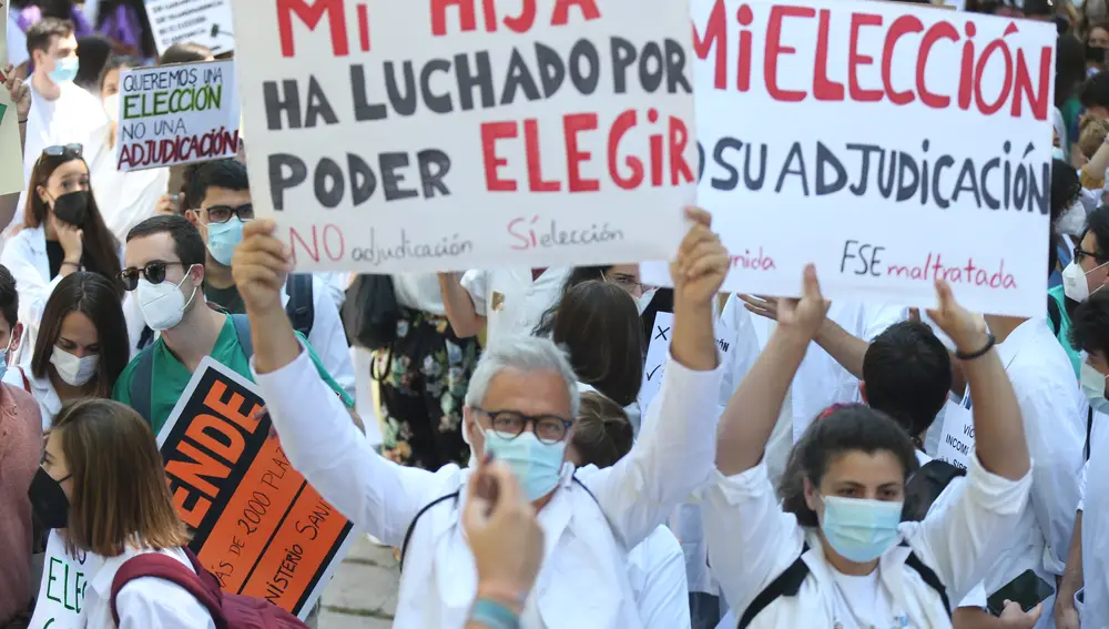 Varios sanitarios con carteles, participan en la manifestación convocada por la plataforma FSE Unida como protesta al sistema de adjudicación de plazas para el MIR este año frente al Ministerio de Sanidad