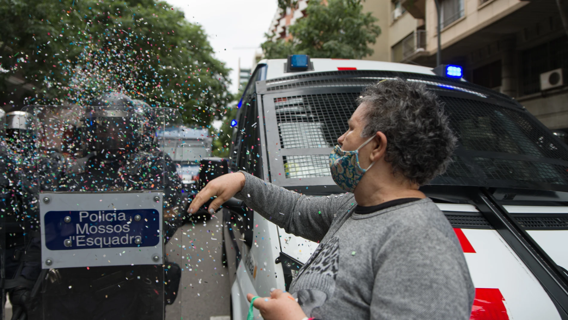 Una mujer, perteneciente a activistas vinculados a sindicatos de la vivienda de Barcelona, frente a los Mossos d'Esquadra en una ocupación de la sede de ERC en la calle Calàbria en protesta por el desahucio del bloque Llavors este martes por la mañana, a 25 de mayo de 2021, en Barcelona, Catalunya (España). En el desahucio han participado agentes antidisturbios de los Mossos d'Esquadra, que también se han trasladado a la sede de ERC. En un comunicado, el Sindicat de Barri de Poble Sec ha lamentado que la intervención de los antidisturbios supone "un incumplimiento del acuerdo con la CUP" del nuevo presidente de la Generalitat, para retirar a los antidisturbios de los desahucios. Los activistas en la sede aseguran que "no se marcharán" hasta que no cese la intervención policial en el bloque Llavors, donde se ha producido una concentración para impedir el paso de la comitiva judicial que debe llevar a cabo el desahucio.25 MAYO 2021;BARCEL