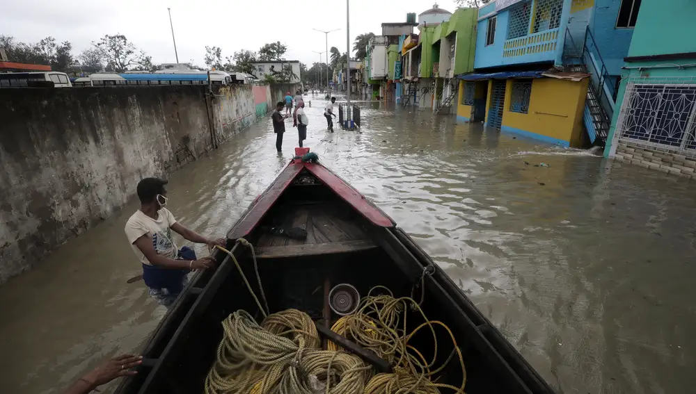 Varias personas preparan un bote para rescatar a personas en medio de una inundación mientras el ciclón Yaas toca tierra en Digha