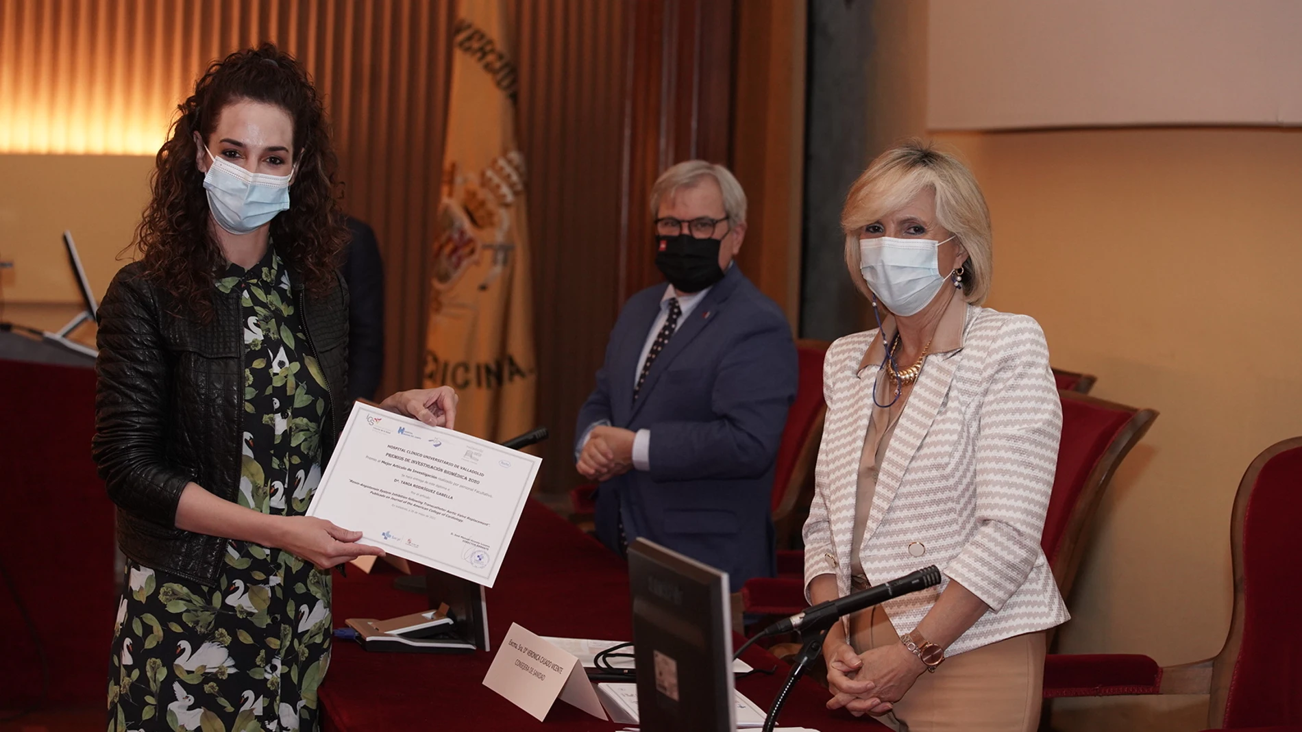 La consejera de Sanidad, Verónica Casado (D), entrega el premio al mejor artículo de Investigación realizado por personal facultativo a Tania Rodríguez Gabella (I), durante la entrega de los 'Premios anuales de investigación del Área de Salud Valladolid Este'