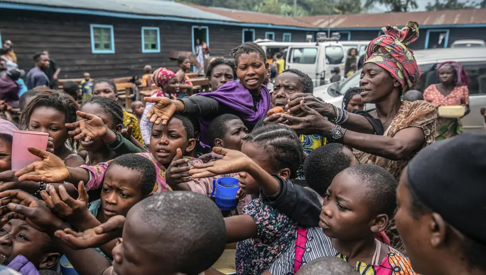 Personas que huyeron de Goma, Congo, se reúnen en un punto de distribución de alimentos en 2021