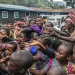 Personas que huyeron de Goma, Congo, se reúnen en un punto de distribución de alimentos en 2021