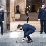 Pere Aragonès coloca una flor sobre la piedra que recuerda a Lluis Companys en la puerta del Palau de la Generalitat