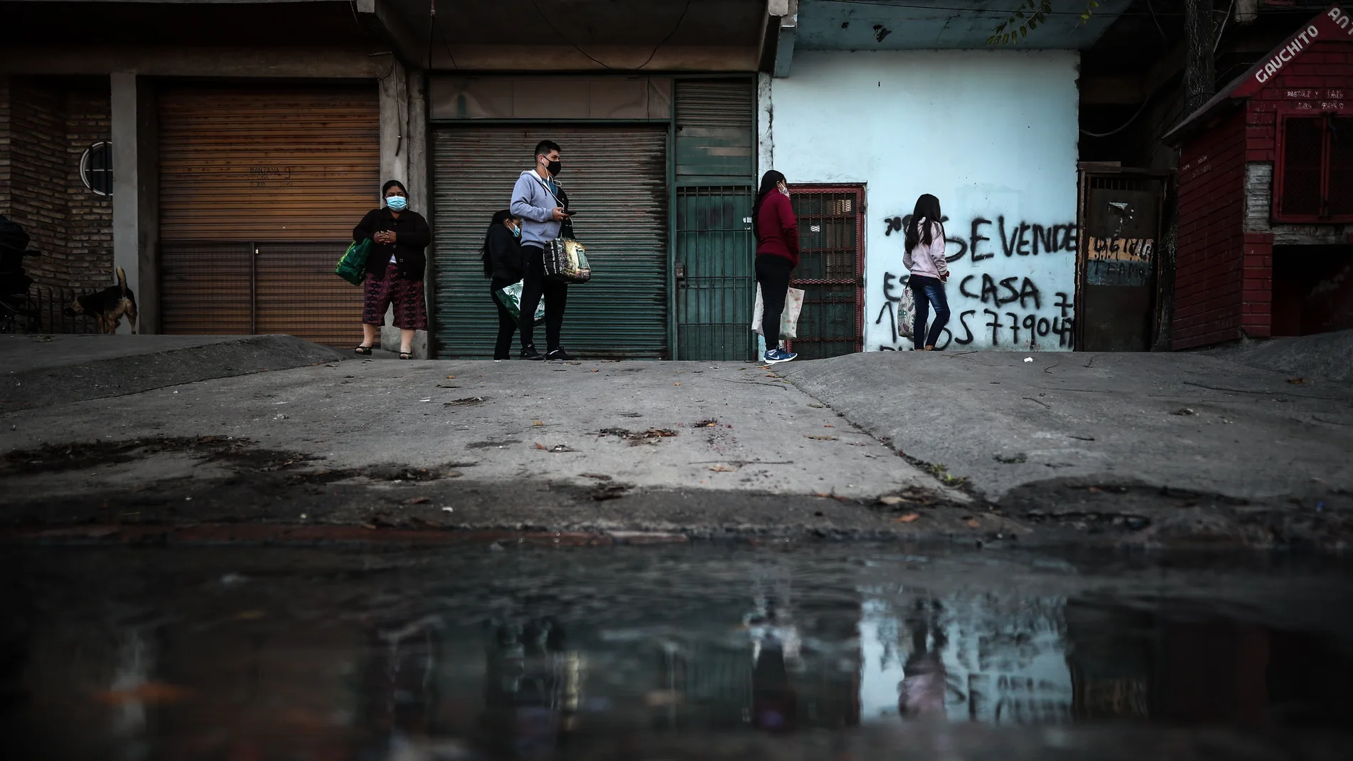 Un grupo de personas espera para recibir alimentos frente a un comedor en Buenos Aires (Argentina
