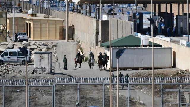 Fuerzas policiales a caballo que patrullan a lo largo de la orilla que une las dos caras de la valla fronteriza de la playa del Tarajal