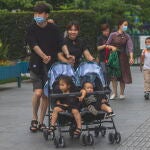 Una pareja de Shanghái (China) pasea a sus dos hijos.