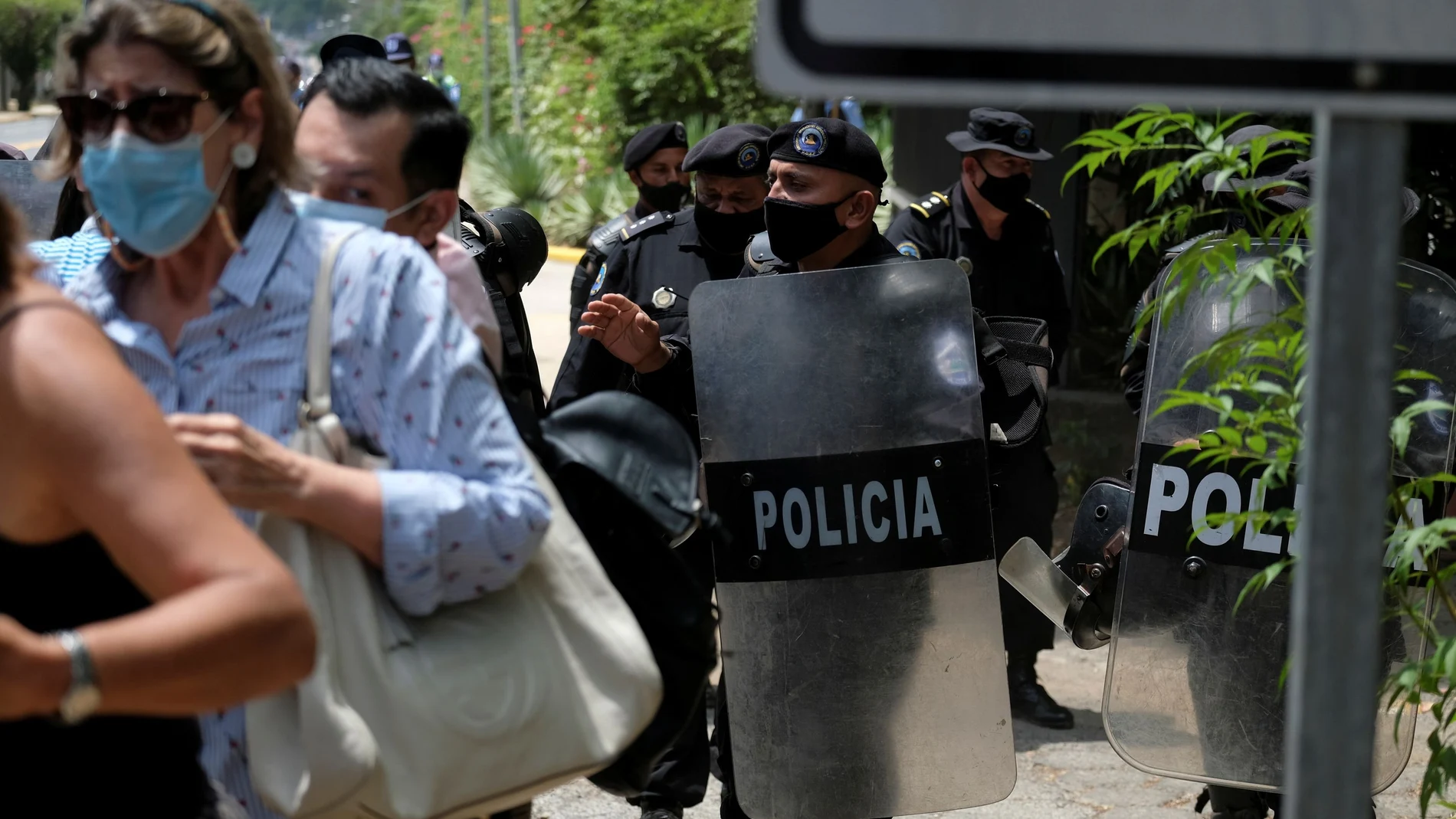 Nicaraguan police officers move journalists from the entrance to the house of opposition leader Cristiana Chamorro after prosecutors sought her arrest for money laundering and other crimes, according to judicial authorities, in Managua, Nicaragua June 2, 2021. REUTERS/Carlos Herrera
