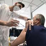 Un sanitario vacuna contra el coronavirus a un hombre en el hospital