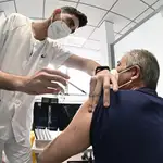 Un sanitario vacuna contra el coronavirus a un hombre en el hospital