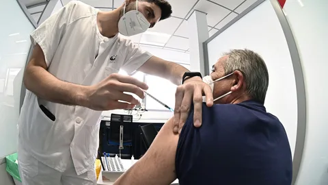 Un sanitario vacuna contra el coronavirus a un hombre en el hospital
