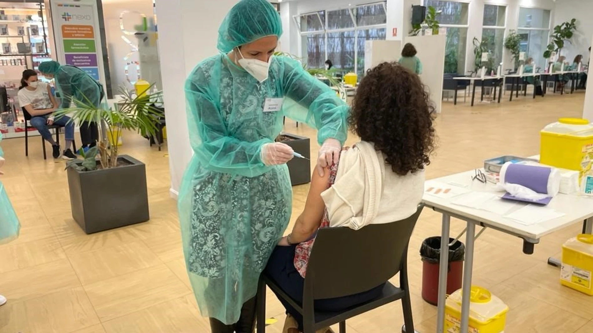 Una farmacéutica inyecta la vacuna a una compañera de profesión en el Colegio de Farmacéuticos de Madrid
