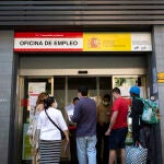 Varias personas esperan a la puerta de una oficina de empleo de Madrid