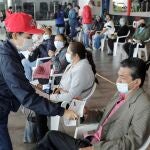Personal de asistencia registra a un grupo de personas que recibirá la vacuna contra la covid-19 hoy, en el Mallplaza, uno de los centros comerciales habilitados como punto de vacunación masiva, en Bogotá (Colombia)