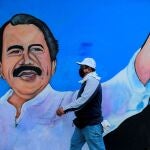 Un hombre con mascarilla pasa por delante del mural del líder sandinista, Daniel Ortega, ayer en Managua