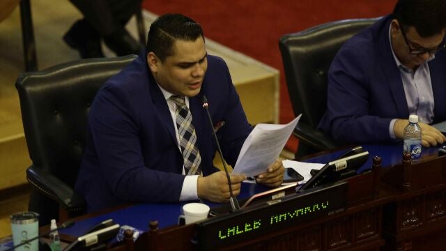 -FOTODELDIA- SAN SALVADOR (EL SALVADOR) 09/06/2021.- El diputado oficialista Caleb Navarro lee el dictamen favorable sobre la ley Bitcon durante la sesión del martes en la Asamblea Legislativa de El Salvador. La Cámara, de mayoría oficialista, aprobó este martes 8 de junio de 2021, la Ley Bitcon, que permitirá el curso legal de dicha criptomoneda, con lo que el país centroamericano se convierte en el primero en el mundo en reconocer este criptoactivo como una moneda legal de intercambio. EFE/MIGUEL LEMUS
