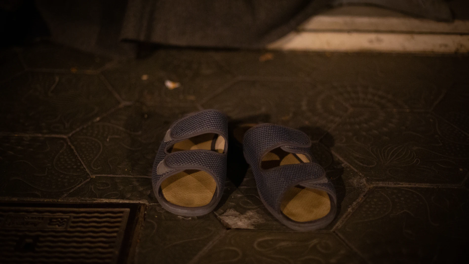 Las sandalias de un hombre sin hogar que duerme en el Paseo de Gracia con Gran Vía de Les Corts Catalan
