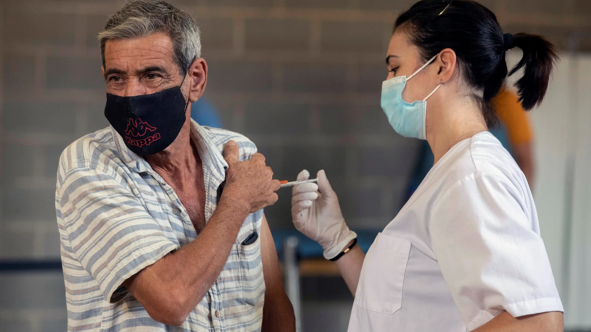 Una enfermera del Servicio Murciano de Salud inyecta a un ciudadano una dosis de la vacuna contra el Covid-19 "Comirnaty-Pfizer-BioNTech" durante la vacunación realizada este viernes en el estadio Nueva Condomina en Murcia. EFE/Marcial Guillén