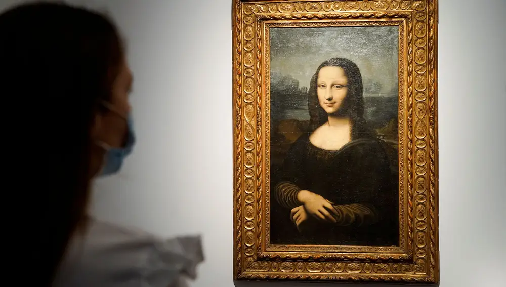 A woman looks at the Hekking &quot;Mona Lisa&quot;, a reproduction of Leonardo Da Vinci's Mona Lisa, painted on canvas by an unknown artist from the 17th century and up for an online sale at Christie?s auction house in Paris, France, June 11, 2021. REUTERS/Lucien Libert