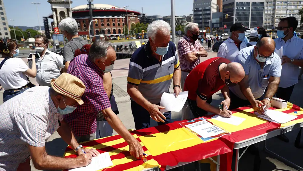 BARCELONA, 13/06/2021.- Varios ciudadanos firman la petición contra la concesión de indultos a los condenados por el "procés" en una mesa instalada por el Partido Popular en Barcelona, este domingo. EFE/Alejandro García