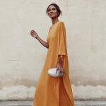 La influencer Carmen de la Cruz con vestido de invitada en color naranja/ Instagram @carmendelacruz