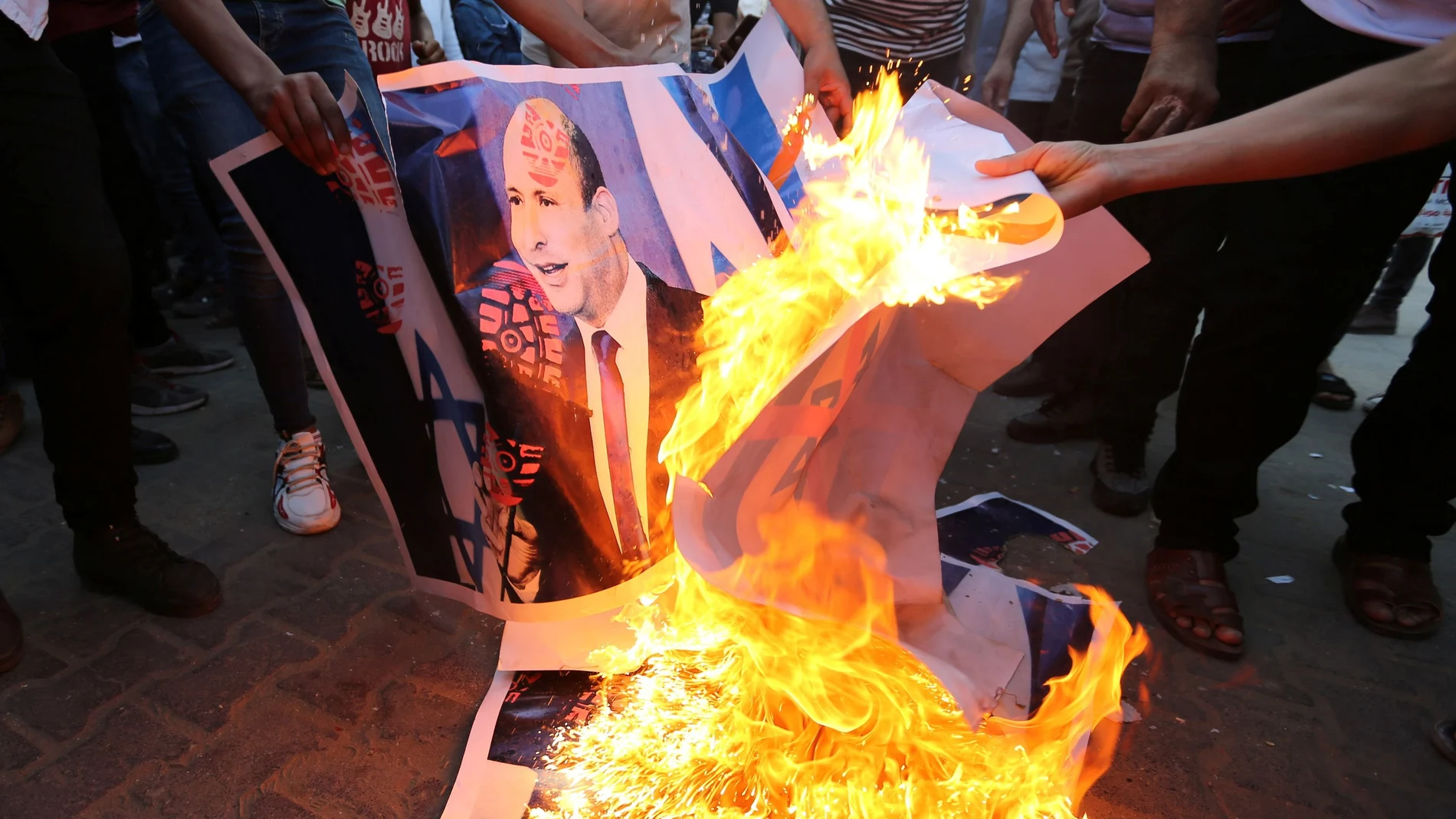 Manifestantes queman un póster con la cara del nuevo primer minisro de Israel, Naftali Bennet. Reuters