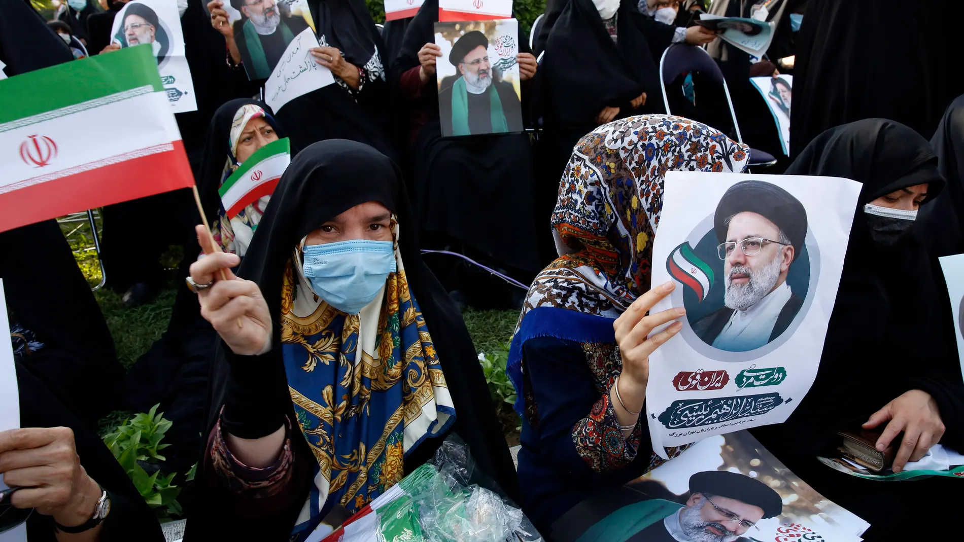 Mujeres seguidoras de Ebrahim Rai con póster con su cara. EFE