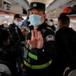 Un policía chino en un avión en Urumqi, Xinjiang