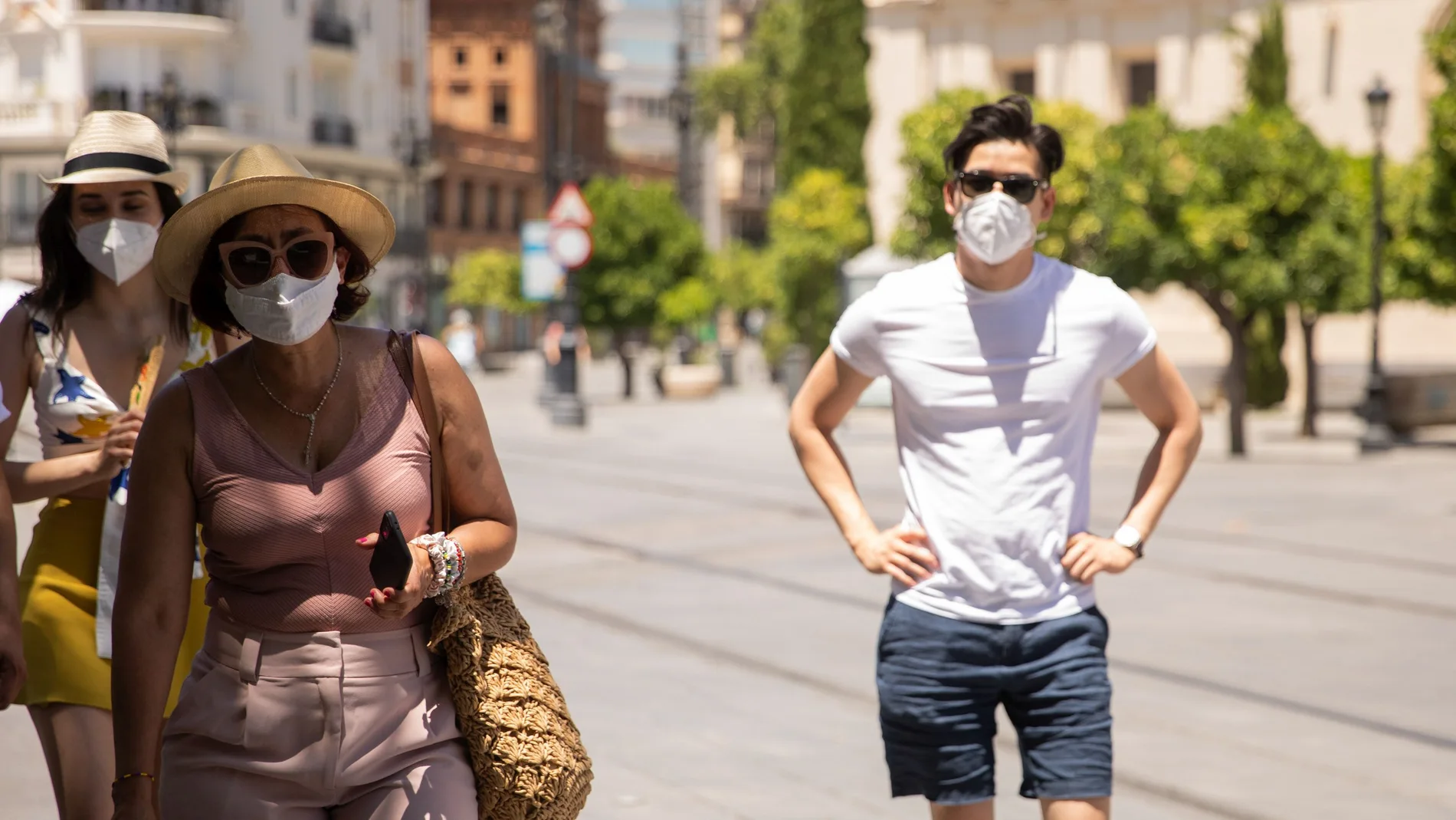 Turistas pasean por el centro de Sevilla con mascarillas, que no serán obligatorias desde el día 26