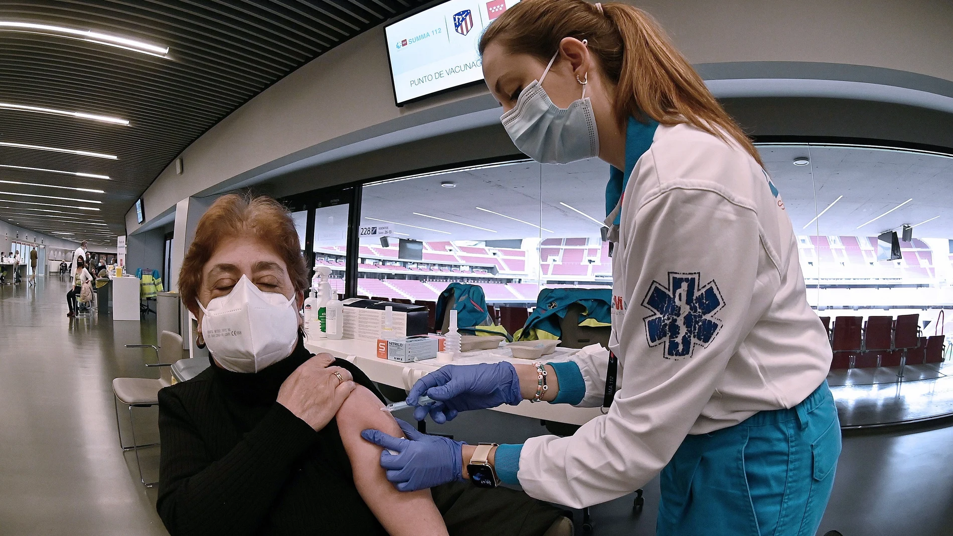 Una sanitaria vacuna a una mujer en el estadio Wanda Metropolitano en Madrid.