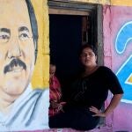 Una imagen se asoma a una ventana de un edificio que contiene un mural del presidente de Nicaragua Daniel Ortega en Catarina