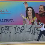 Un hombre con mascarilla pasa por delante de un cartel de la pareja presidencial Daniel Ortega y de su mujer, la vicepresidenta Rosario Murillo en Managua