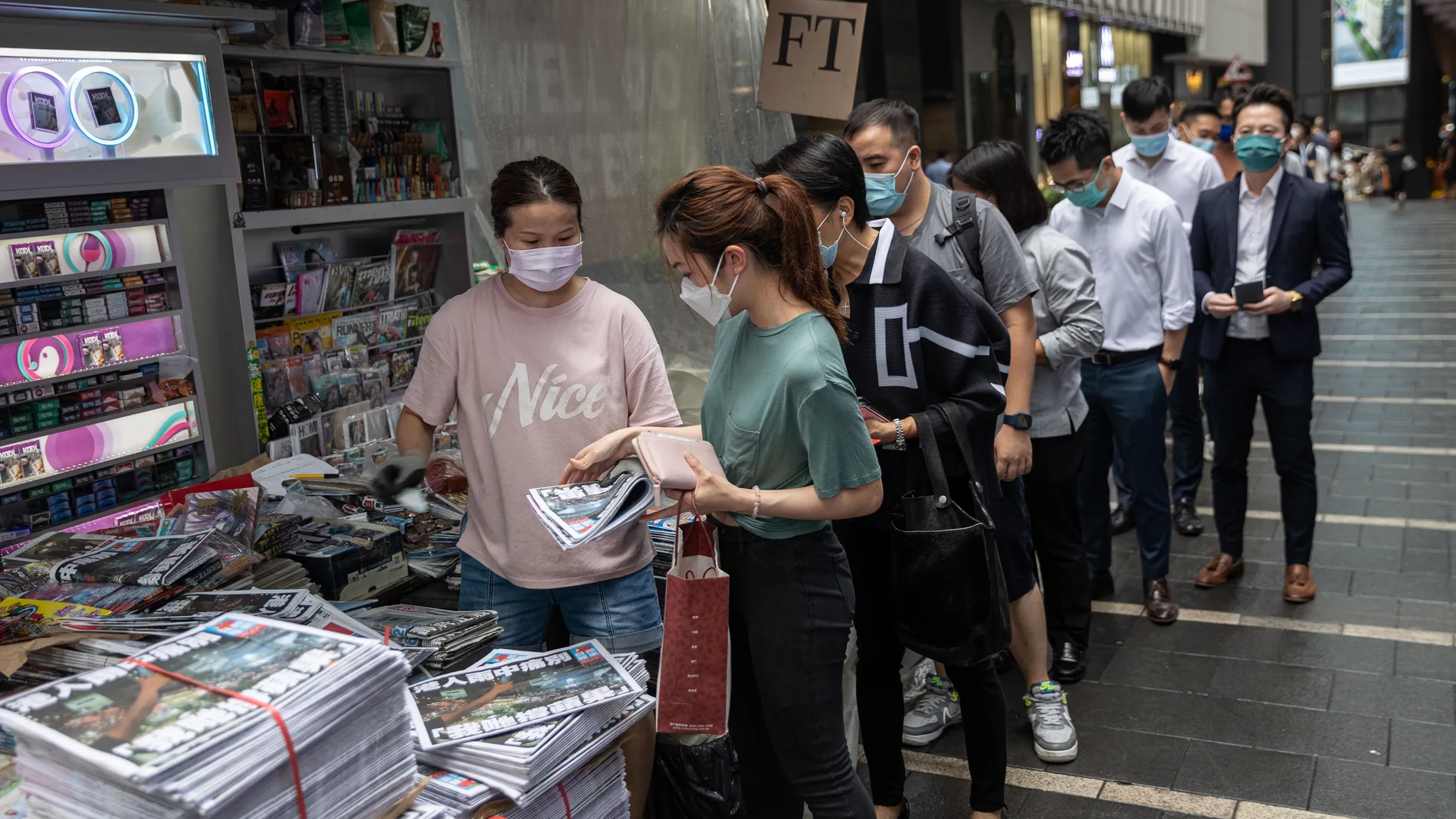 Hongkoneses hacen cola para comprar la última edición impresa del "Apple Daily" en el centro de la ciudad autónoma