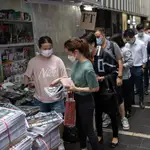 Hongkoneses hacen cola para comprar la última edición impresa del "Apple Daily" en el centro de la ciudad autónoma