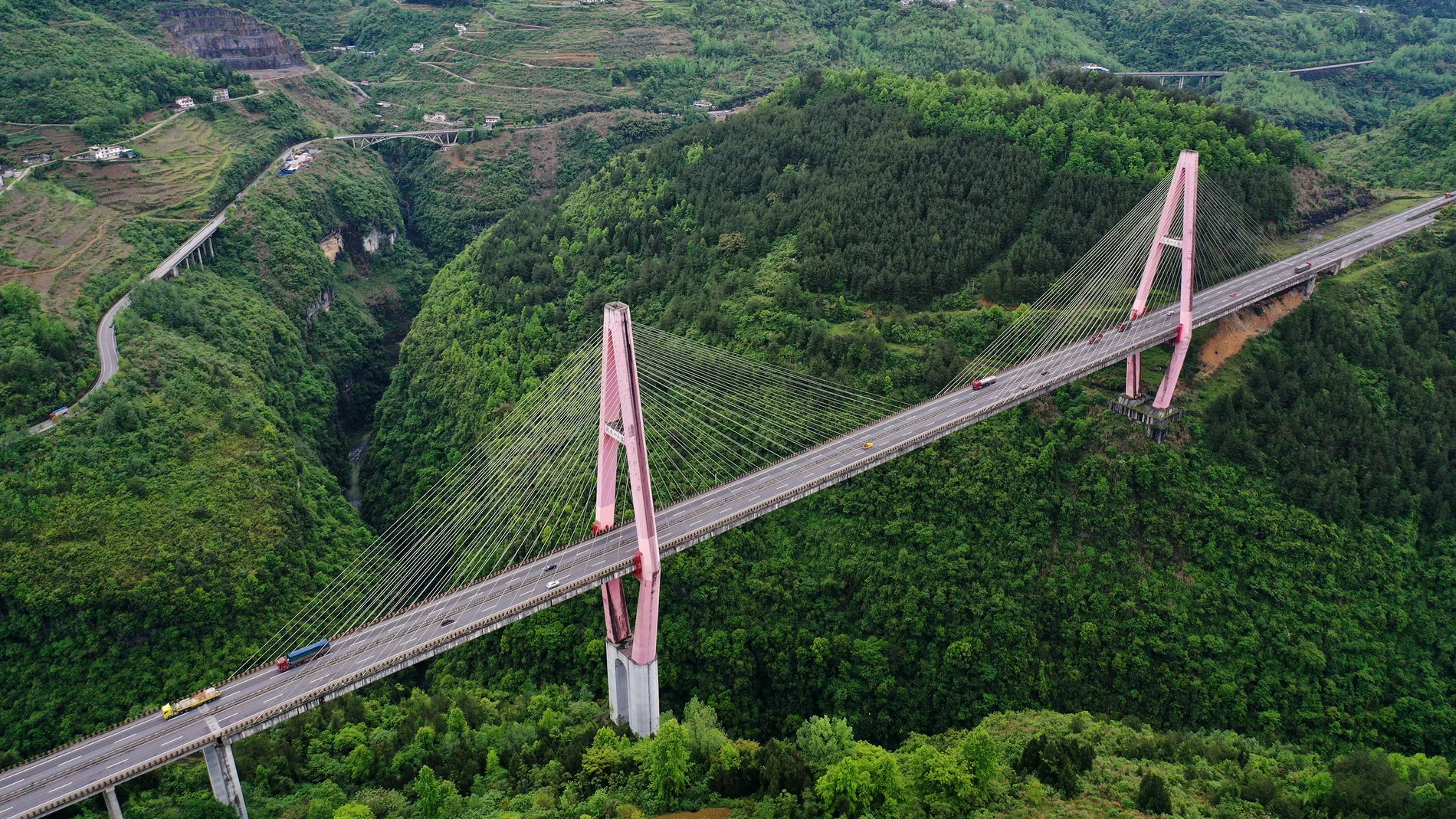 Los coches circularon por el puente Wulingshan de la autopista Chongqing-Hunan en el condado Qianjiang de Chongqing el 25 de abril de 2021. La autopista, de 848 kilómetros de longitud, conecta dos regiones pobres: el sureste de Chongqing y el oeste de la provincia de Hunan.