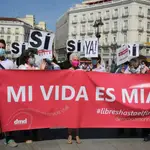 Un grupo de personas se reúnen sosteniendo pancartas durante la concentración en la Puerta del Sol