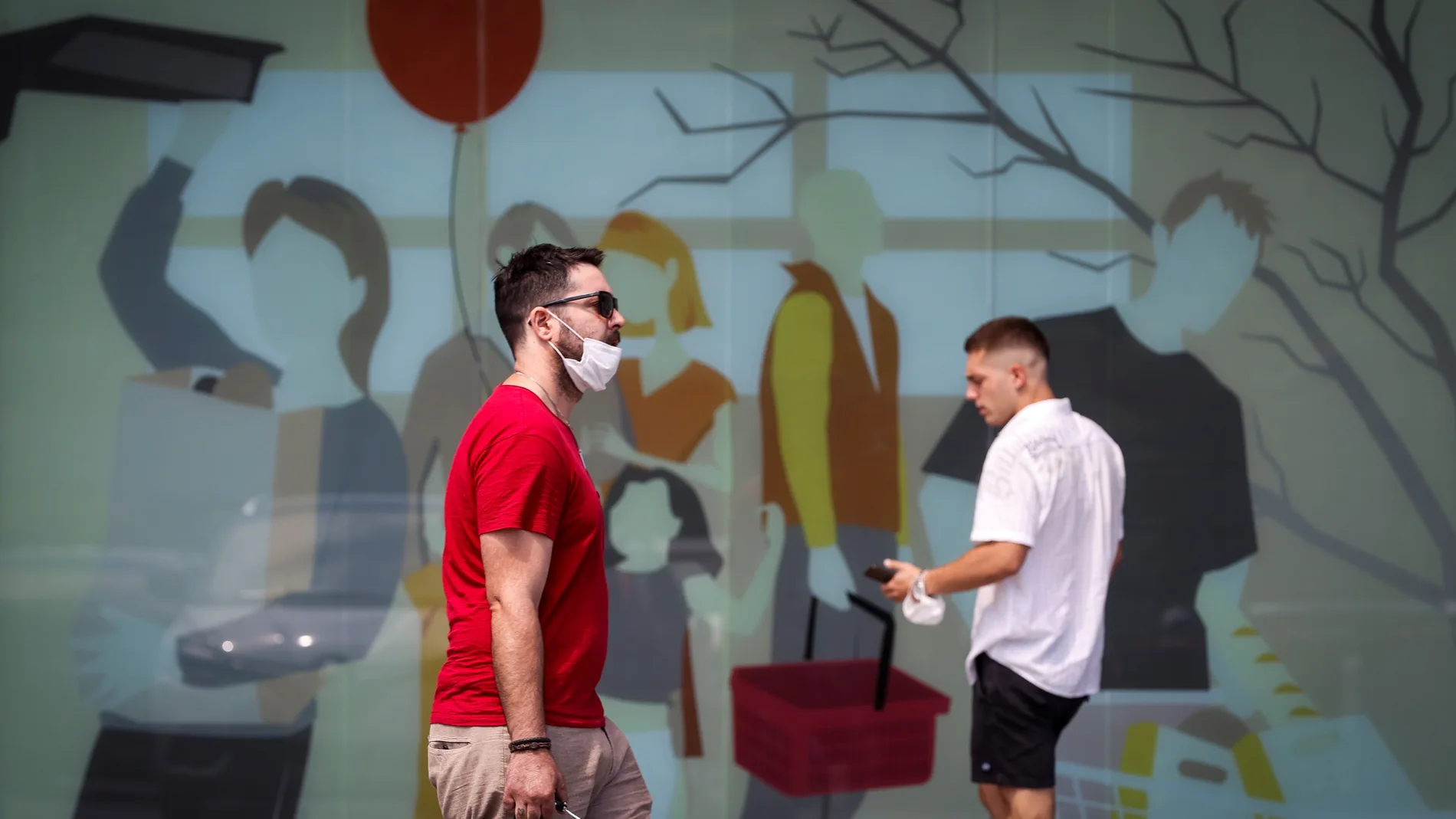 Dos hombres caminan con la mascarilla quitada este sábado en San Sebastián