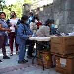 Decenas de personas acuden al reparto de alimentos que la Fundación Madrina realiza en la Plaza San Amaro en Madrid el pasado junio